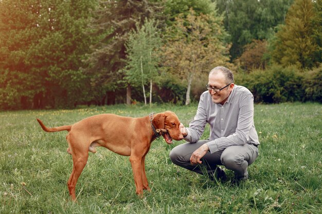 adult man in a summer park with an old dog